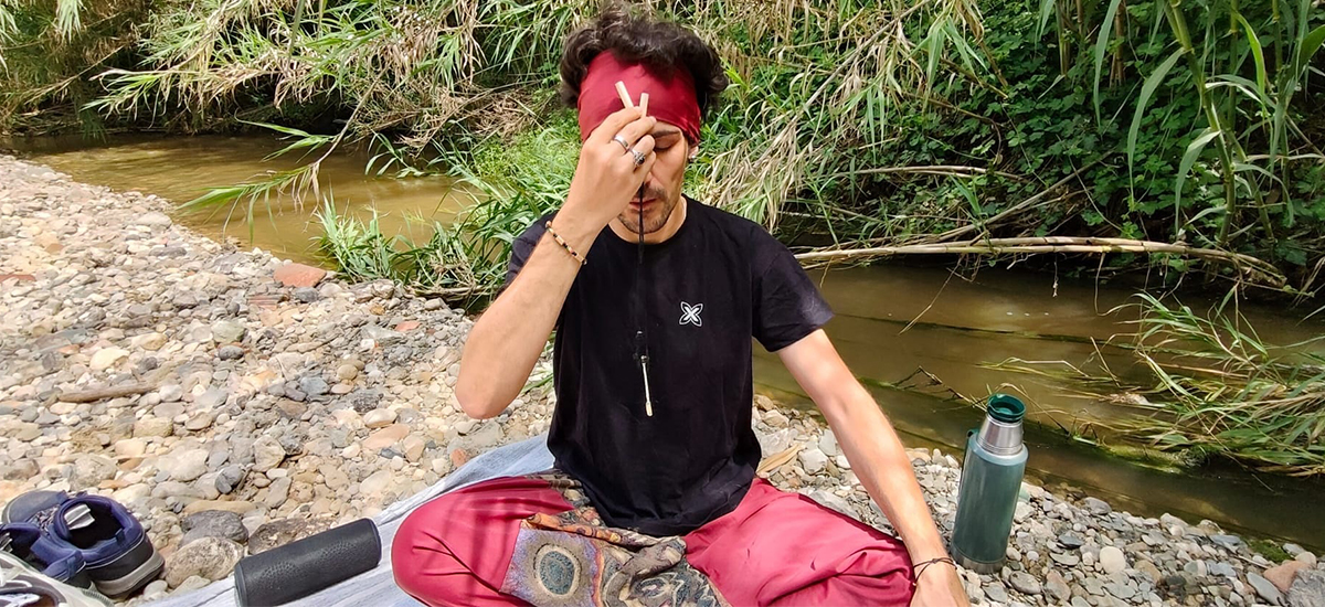 Hombre tomando Rapé en el río